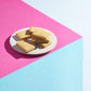 plain shortbread on plate on pink and blue background